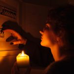 Young,Woman,With,Candles,In,Complete,Darkness,Examines,Fuse,Box